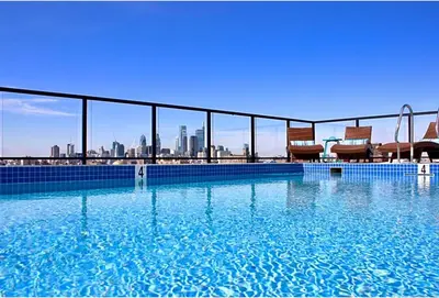 a large swimming pool with a city skyline in the background at Nice 1BR Luxury Flat - Pool & Gym in Philadelphia