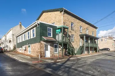 a brick building on the corner of a street at Cozy & Modern 3-Bed Retreat - 8 Mins to Bridge St in Phoenixville
