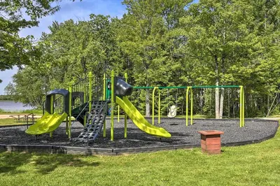 a playground with a slide in a park at Deck and Fire Pit Pet-Friendly Pocono Lake Abode! in Pocono Lake