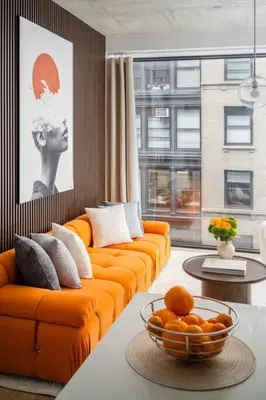 an orange couch in a living room with a bowl of oranges at Luxury Full Floor Chelsea Apt St 7 in New York