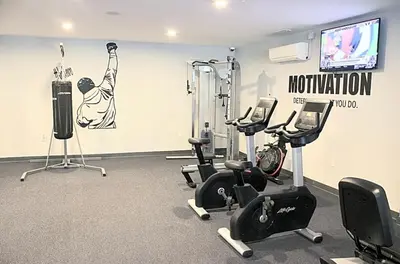 a gym with cardio equipment and a flat screen tv at Glam Flat with View, Pool, Deck in Philadelphia