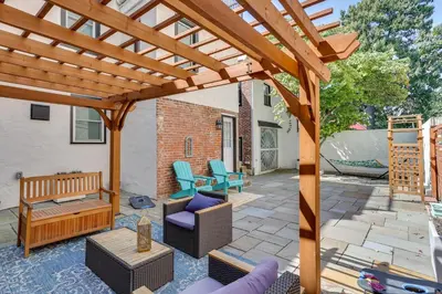 a wooden pergola on a patio with furniture at Modern Marvel at University City in Philadelphia