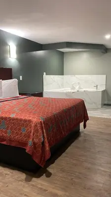 a bedroom with a bed with a red blanket on it at Wilkes-Barre lodge in Wilkes-Barre