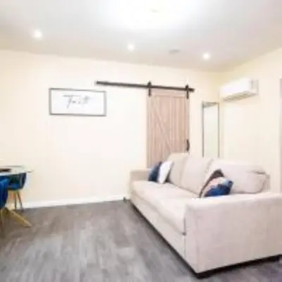 a living room with a white couch and a table at 1BR Apt In Darby 18Min To Lincoln Financial Field in Darby