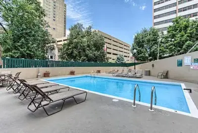 a swimming pool with chaises and chairs next to a building at PP 1306 Modern Corporate 1br, pool, Gym in Harrisburg