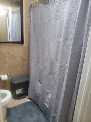 a shower curtain in a bathroom with a toilet at Tranquility Room by the Airport -Shared space in Darby