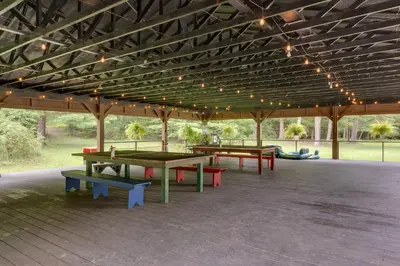 a group of picnic tables under a pavilion with lights at Community Perks Elk Creek Escape - Deluxe Cabin C in Hillsgrove