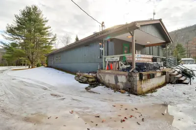 a building with snow on the ground in front of it at Shared Perks Deluxe Cabin B at Elk Creek Escape! in Hillsgrove