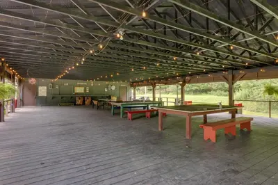 a pavilion with ping pong tables and benches in it at Deluxe Cabin A at Elk Creek Escape Pet Friendly! in Hillsgrove
