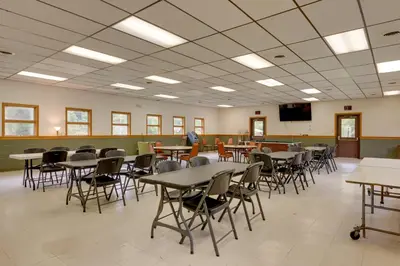 a class room with tables and chairs and a tv at Pet-Friendly Deluxe Cabin F with Grill in Hillsgrove in Hillsgrove