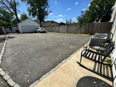 a parking lot with a bench in a driveway at Private 1st floor Apartment - Only 5 min Away from Newark Airport and 30 min to NYC in Elizabeth
