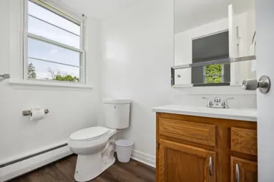 a bathroom with a toilet and a sink and a window at Pine Brook 1108 I Pool Gym I Free Parking ! in Newark