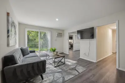 a living room with a couch and a table at Pine Brook 120 I Pool Gym I Free Parking ! in Newark