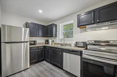 a kitchen with black cabinets and stainless steel appliances at Pine Brook 120 I Pool Gym I Free Parking ! in Newark