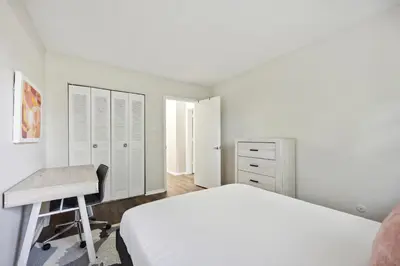 a white bedroom with a bed and a desk at Pine Brook 1202 I Pool Gym I Free Parking ! in Newark