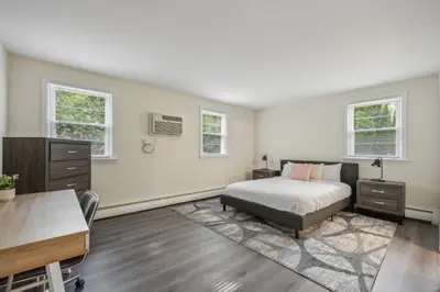 a bedroom with a bed and a desk and two windows at Pine Brook 1302 I Pool Gym I Free Parking ! in Newark