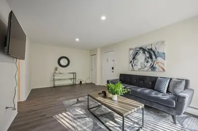 a living room with a black couch and a table at Pine Brook 410 I Pool Gym I Free Parking ! in Newark