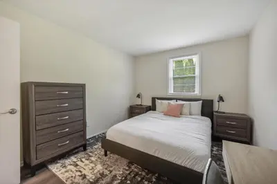 a bedroom with a bed and a dresser and a window at Pine Brook 410 I Pool Gym I Free Parking ! in Newark