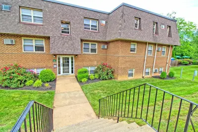 a brick house with a staircase in the yard at Pine Brook 509 I Corporate 15Br Apt I Parking in Newark