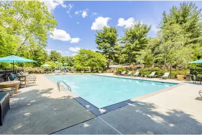 a swimming pool with chairs and umbrellas at Pine Brook 618 I Cozy & Roomy I Gym & Pool in Newark