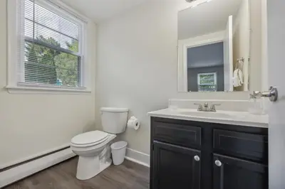 a bathroom with a toilet and a sink and a mirror at Pine Brook 816 I Corporate 2Br Apartment ! in Newark