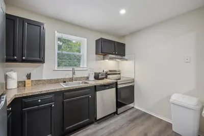 a kitchen with black cabinets and a sink at PineBrook 914 I Popular 2Br Apartment for rent ! in Newark