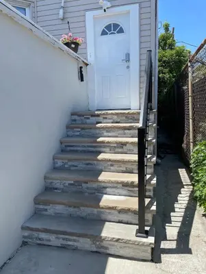 a set of stairs leading to a white door at New York City Apartment Near Free Ferry Boat! in Stapleton