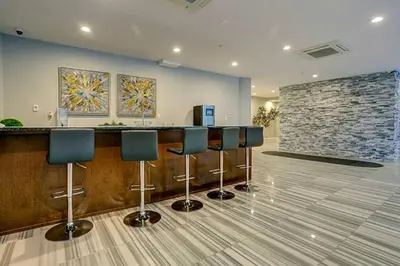 a lobby with a bar with blue chairs and a stone wall at Modern 1BR with Rooftop Pool & Gym in Philadelphia