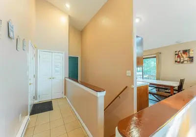a hallway with a staircase leading to a dining room at Charming Lakefront Getaway with Hot Tub & Game Room Perfect for Families! in East Stroudsburg