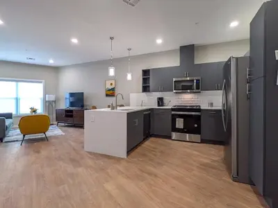 a kitchen with gray cabinets and a yellow chair at 224 Brand New 1 Bedroom 1 Bath 1 Kitchen 1 Liv in Dunellen