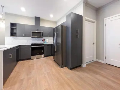 a large kitchen with stainless steel appliances and wood floors at 222 Brand New 2 Bedroom 1 KIT 2 BATH 1 Living in Dunellen