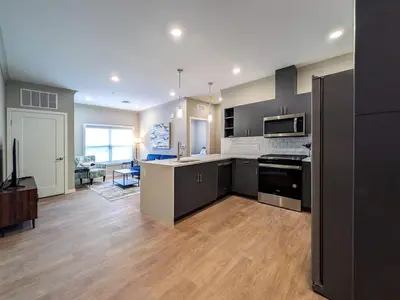 a large kitchen with black appliances and a living room at 222 Brand New 2 Bedroom 1 KIT 2 BATH 1 Living in Dunellen