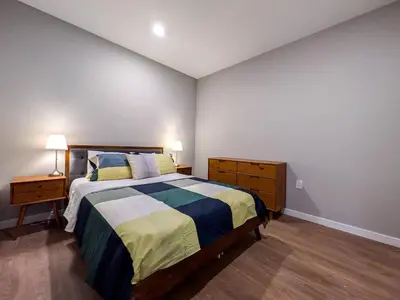 a bedroom with a bed and a dresser and lamp at 222 Brand New 2 Bedroom 1 KIT 2 BATH 1 Living in Dunellen