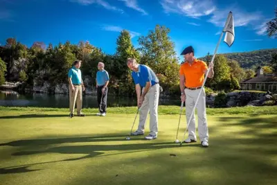 a group of men playing golf on a golf course at Luxe 10 guest Cottage Ski-Golf-Firepit-Lakes-Hike in Vernon Township