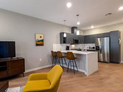 a kitchen with a yellow chair and a kitchen counter at 310 Brand New 1 Bedroom 1 Bath 1 Full Kit 1 Liv in Dunellen