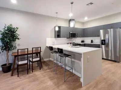 a kitchen with a refrigerator and a table and chairs at 313 brand new 3 bedroom 2 bath in Dunellen