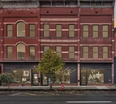 a red brick building with a red fire hydrant in front of it at Wonder Honesdale -Loft A2 in Honesdale