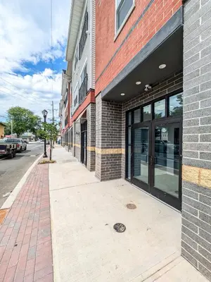 an empty sidewalk in front of a brick building at 221 Modern 1BR Apt Walk to NJT in Dunellen