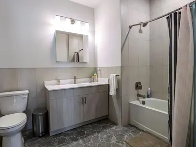a bathroom with a toilet and a sink and a bath tub at 212 Modern 1BR Apt Walk to NJTransit in Dunellen