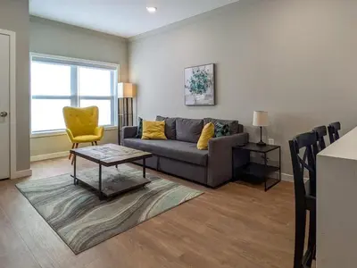 a living room with a couch and a yellow chair at 212 Modern 1BR Apt Walk to NJTransit in Dunellen