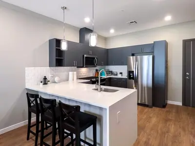 a kitchen with a white counter and black cabinets at 329 Modern 1BR Apt Walk to NJT in Dunellen