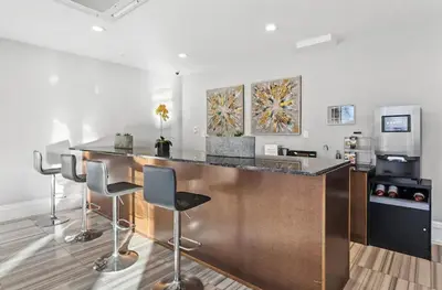 a kitchen with a bar with stools in a room at High-End 1BR with Rooftop Amenities in Philadelphia