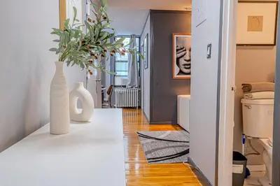 a living room with a white vase on a table at Stylish 3Bd in Manhattan near the Empire State Building in New York