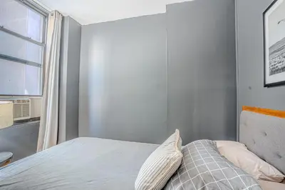a small bedroom with a bed with a window at Stylish 3Bd in Manhattan near the Empire State Building in New York