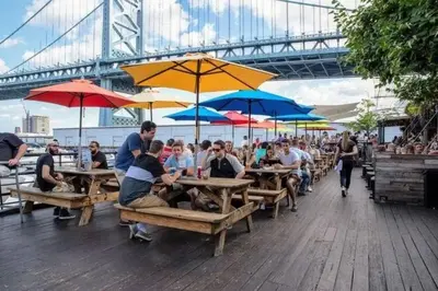 a group of people sitting at tables with umbrellas at Waterfront Studio - Near Fishtown and Old City in Philadelphia