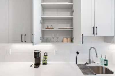 a kitchen with white cabinets and a sink at King Bed - Stunning Pier Views - Near Fishtown in Philadelphia