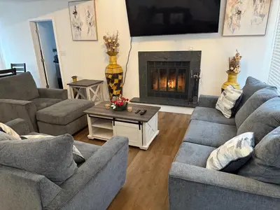 a living room with two couches and a fireplace at POCONOS everything close to Luxury vacational home in the heart of poconos with 3 outdoor pools for the public of the Tobyhanna community in Tobyhanna