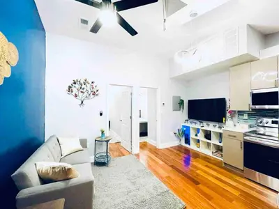a living room with a couch and a kitchen at Downtown City Hall near Kimmel Center 2BD Suite in Philadelphia