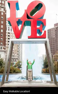 a man standing in front of a large sign at Rittenhouse Square near Kimmel Center Studio Suite in Philadelphia