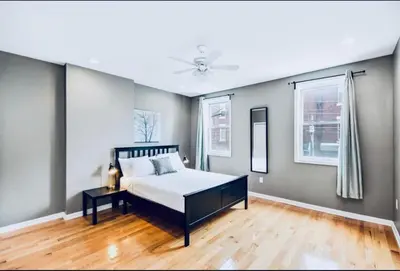 a bedroom with a bed and two windows at Modern Home w. Deck in Passyunk Square in Philadelphia